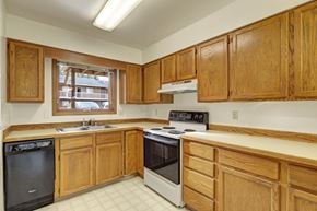 Anchorage apartment for rent - A kitchen with wooden cabinets and a black dishwasher.