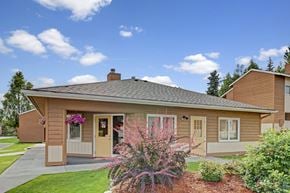 Anchorage apartment for rent - A house with a brown roof and a brown wall with a white door and windows.