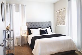 Springdale apartment for rent - A bedroom with a large bed and a mirror on the wall.