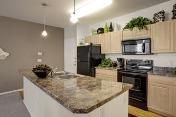 Phoenix apartment for rent - A kitchen with granite countertops and black appliances.