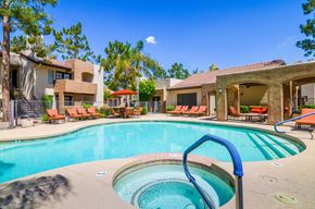 Scottsdale apartment for rent - A resort-style pool area here at Desert Horizon featuring a sparkling swimming pool with a separate spa and built-in steps. Lounge chairs with bright cushions line the deck, while shaded seating areas and surrounding trees create a relaxing atmosphere. Nearby apartment buildings and landscaped grounds complete the inviting community setting.