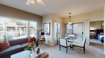 Chandler apartment for rent - A living room with a grey couch, a coffee table, and a dining table with chairs.