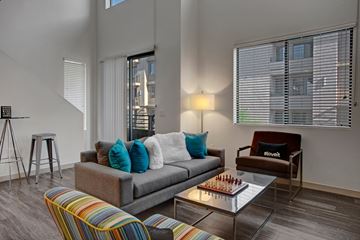 Phoenix apartment for rent - A living room with a grey couch and a glass coffee table.