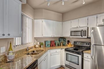 Phoenix apartment for rent - A kitchen with white cabinets and stainless steel appliances.