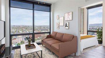 Phoenix apartment for rent - A living room with a brown couch and a view of the city.