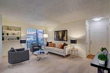 Phoenix apartment for rent - A living room with a grey sofa, a black table, and a painting on the wall.