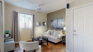 Mesa apartment for rent - A living room with a white couch and a ceiling fan.
