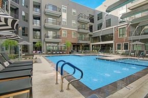 Phoenix apartment for rent - A large swimming pool is surrounded by apartment buildings.