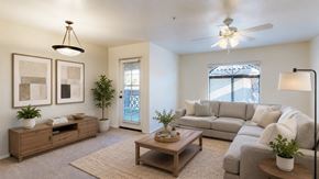 Glendale apartment for rent - A living room with a grey couch, a wooden coffee table, and a ceiling fan.