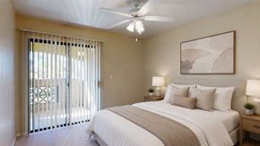 Glendale apartment for rent - A bedroom with a large bed, a ceiling fan, and a painting on the wall.