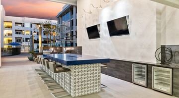 Tempe apartment for rent - A modern kitchen with a long counter and chairs.
