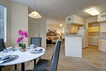 Gilbert apartment for rent - A dining room with a table set for two and a kitchen in the background.