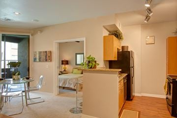 Peoria apartment for rent - A kitchen with a refrigerator, sink, and a dining table with chairs.
