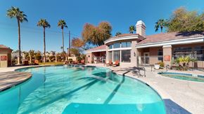 Chandler apartment for rent - A resort-inspired swimming pool here at Dobson Towne Center featuring sparkling blue water, a relaxing spa, and a spacious sun deck lined with lounge chairs. Surrounded by palm trees and beautifully maintained landscaping, the pool area offers inviting seating and a welcoming clubhouse backdrop, creating the perfect setting to unwind, soak up the sun, and enjoy Arizona living.