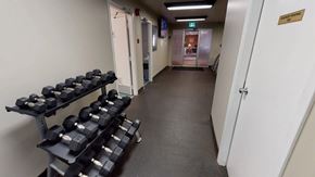 Edmonton apartment for rent - A convenient fitness area here at Cambridge West with a full set of free weights, rubber flooring, and bright overhead lighting, located near the community lounge for easy access.