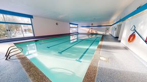 Edmonton apartment for rent - A bright indoor swimming pool here at Cambridge West with clear water, lap lanes, and wide deck space, featuring large windows for natural light and a clean, relaxing atmosphere.