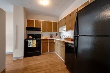 Regina apartment for rent - A black refrigerator is in the corner of a kitchen.