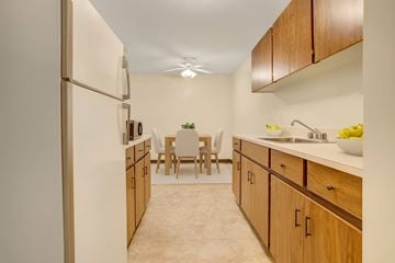 Saskatoon apartment for rent - A kitchen with wooden cabinets and a white refrigerator.