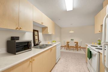 Leduc apartment for rent - A kitchen with wooden cabinets and a white refrigerator.