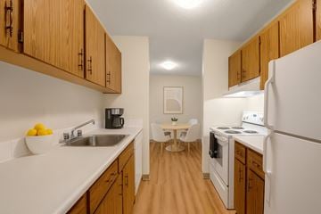 St. Albert apartment for rent - A kitchen with wooden cabinets and white appliances.