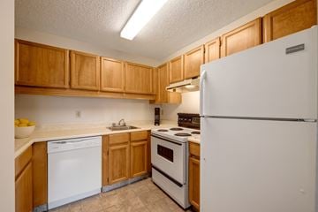 St. Albert apartment for rent - A kitchen with wooden cabinets and white appliances.