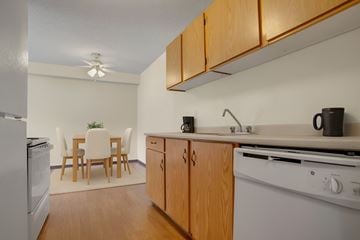 Saskatoon apartment for rent - A kitchen with wooden cabinets and a white stove top oven.
