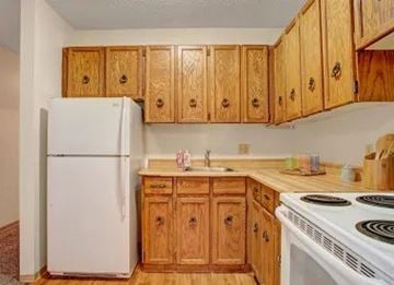 Regina apartment for rent - A kitchen with wooden cabinets and a white refrigerator.