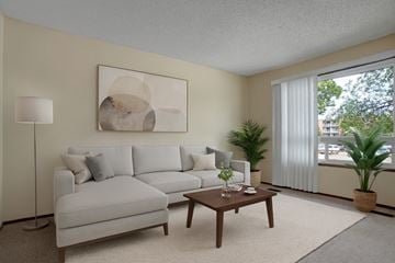 Saskatoon apartment for rent - A living room with a white couch, a coffee table, and a painting on the wall.
