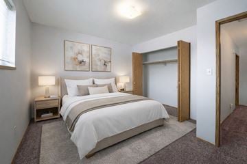Dawson Creek apartment for rent - A bedroom with a large bed and two lamps.