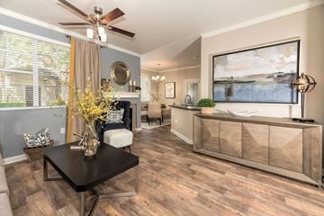 Sacramento apartment for rent - A modern living room with a black coffee table and a large painting on the wall.