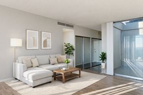 Sacramento apartment for rent - A modern living room with a white sofa, a wooden coffee table, and a plant.