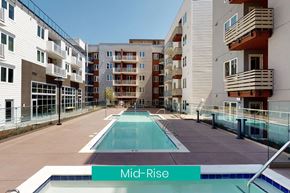 Sacramento apartment for rent - A swimming pool in the middle of a courtyard surrounded by apartment buildings.