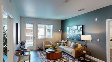 Sacramento apartment for rent - A living room with a couch, coffee table, and a painting on the wall.