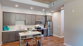 Sacramento apartment for rent - A kitchen with a table and chairs in front of a refrigerator.
