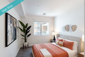 Sacramento apartment for rent - A bedroom with a bed, a plant, and a painting on the wall.