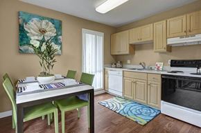 Sacramento apartment for rent - A kitchen with a table and chairs and a flower painting on the wall.