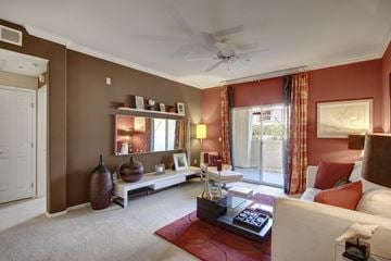 Moreno Valley apartment for rent - A living room with a white couch and a red rug.