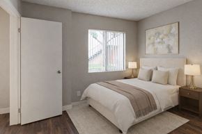 San Bernardino apartment for rent - A bedroom with a large bed and a painting on the wall.