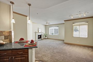 Moreno Valley apartment for rent - A living room with a fireplace and a dining table set for two.