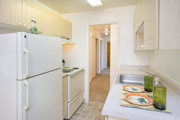 Colorado Springs apartment for rent - A kitchen with a white refrigerator and a sink.