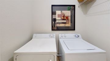 Colorado Springs apartment for rent - A picture of a fridge is hanging on the wall above two washing machines.