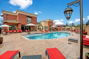 Colorado Springs apartment for rent - A pool area with a red bench and a lamp post.