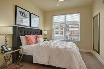 Colorado Springs apartment for rent - A bedroom with a large bed and a window with blinds.
