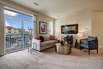 Colorado Springs apartment for rent - A living room with a white couch, a coffee table, and a painting on the wall.