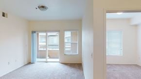 Salt Lake City apartment for rent - A spacious room with a carpeted floor and a sliding glass door leading to a balcony.
