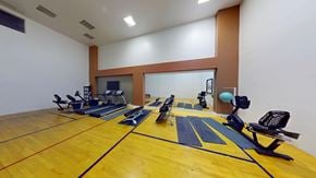 Colorado Springs apartment for rent - A gym with a yellow floor and exercise equipment.