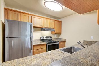 Stainless steel appliances in an open kitchen with plenty of cabinet storage