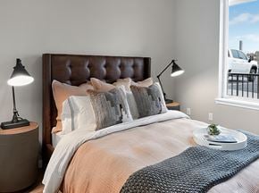 Wenatchee apartment for rent - A bedroom with a large bed and a window overlooking a parking lot.