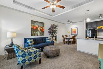 Oklahoma City apartment for rent - A living room with a blue couch and a ceiling fan.