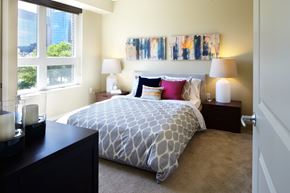 Minneapolis apartment for rent - A bedroom with a patterned bedspread and two lamps on bedside tables.